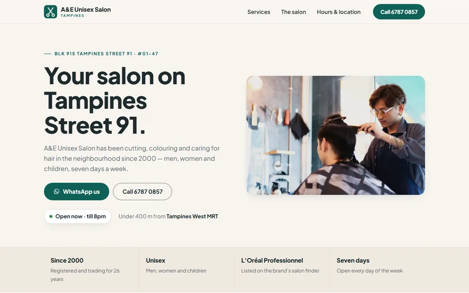 The A&E Unisex Salon homepage: &lsquo;Your salon on Tampines Street 91&rsquo; in dark type on warm sand, beside a photograph of a stylist trimming a client's hair.