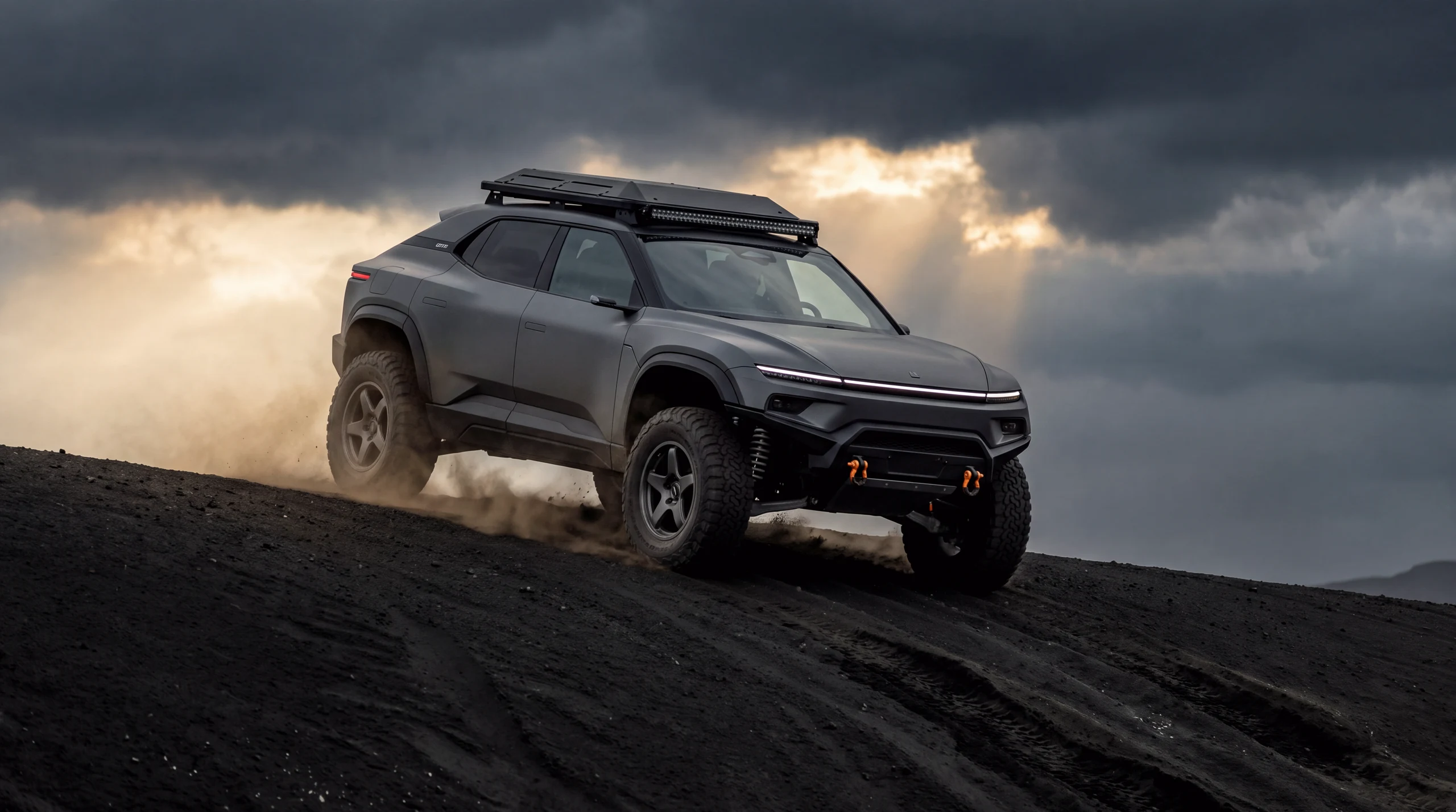 The K4 BREKKA climbing an ash dune under a storm sky: a high-riding matte-grey raider with massive all-terrain tyres, a full-width auxiliary light bar and dust curling off its rear wheels.