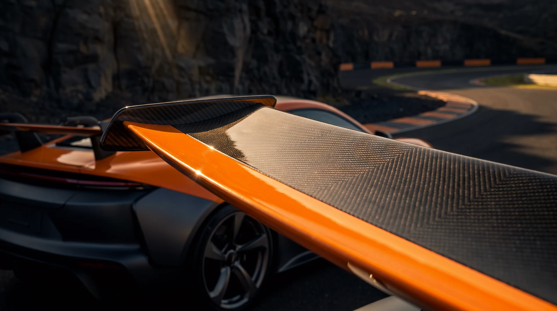Along the SERRA's signal-orange swan-neck rear wing, evening light on its leading edge, basalt cliffs soft behind.