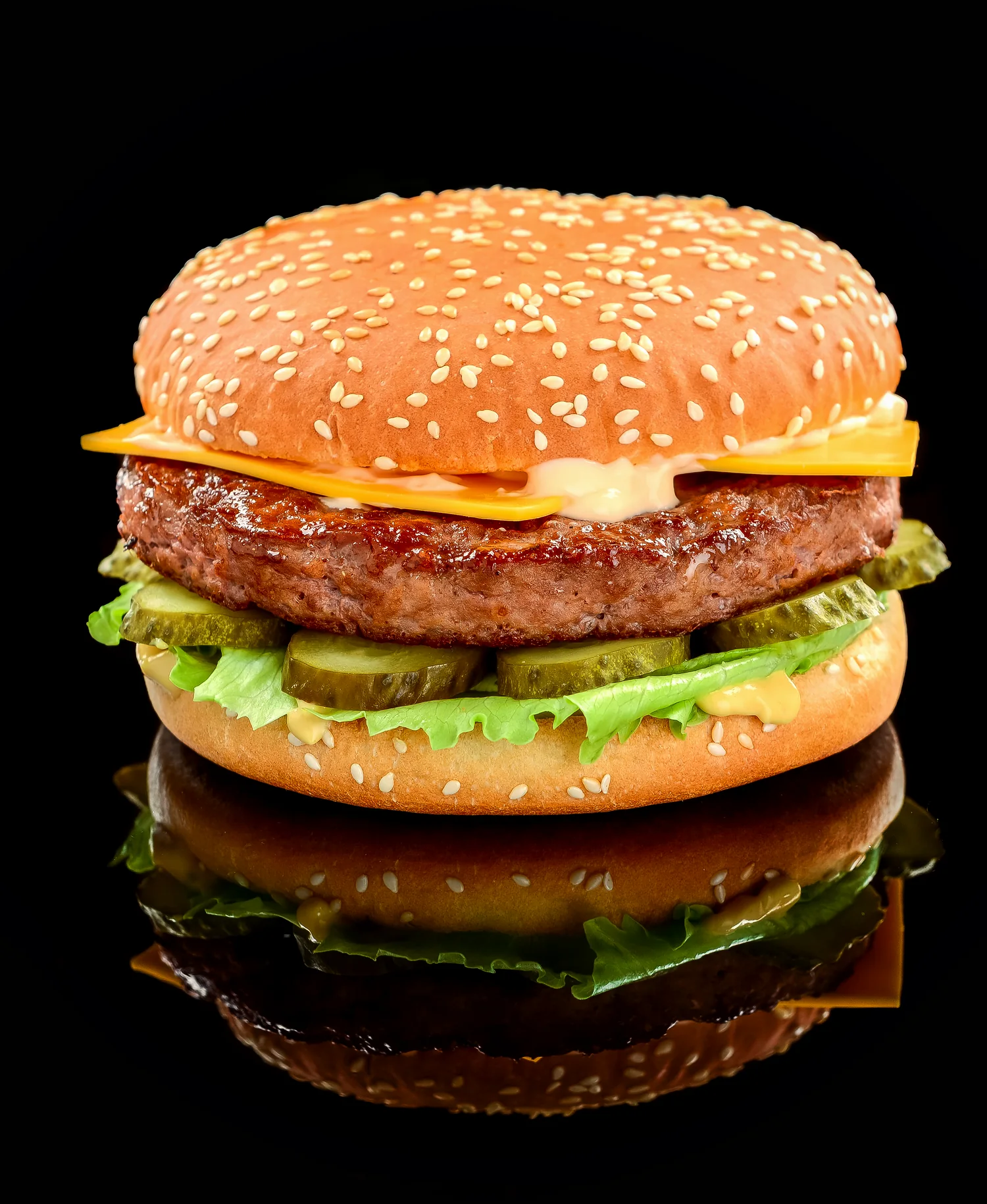 The Double: a two-patty cheeseburger on a sesame bun, lit against black with its reflection beneath.