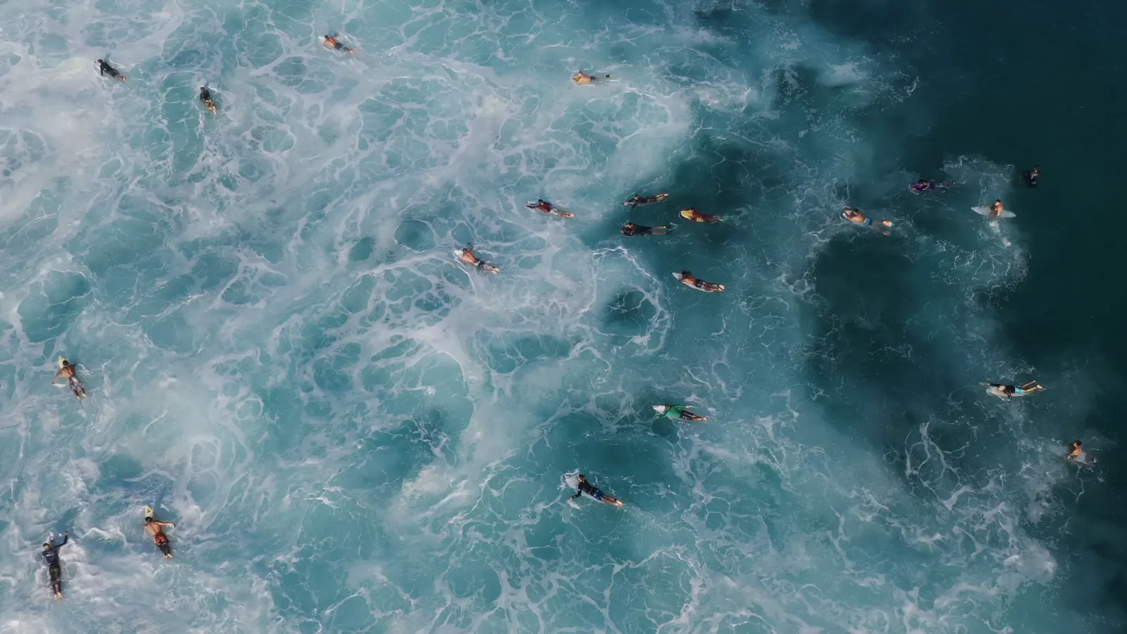 Surfers scattered across turquoise water