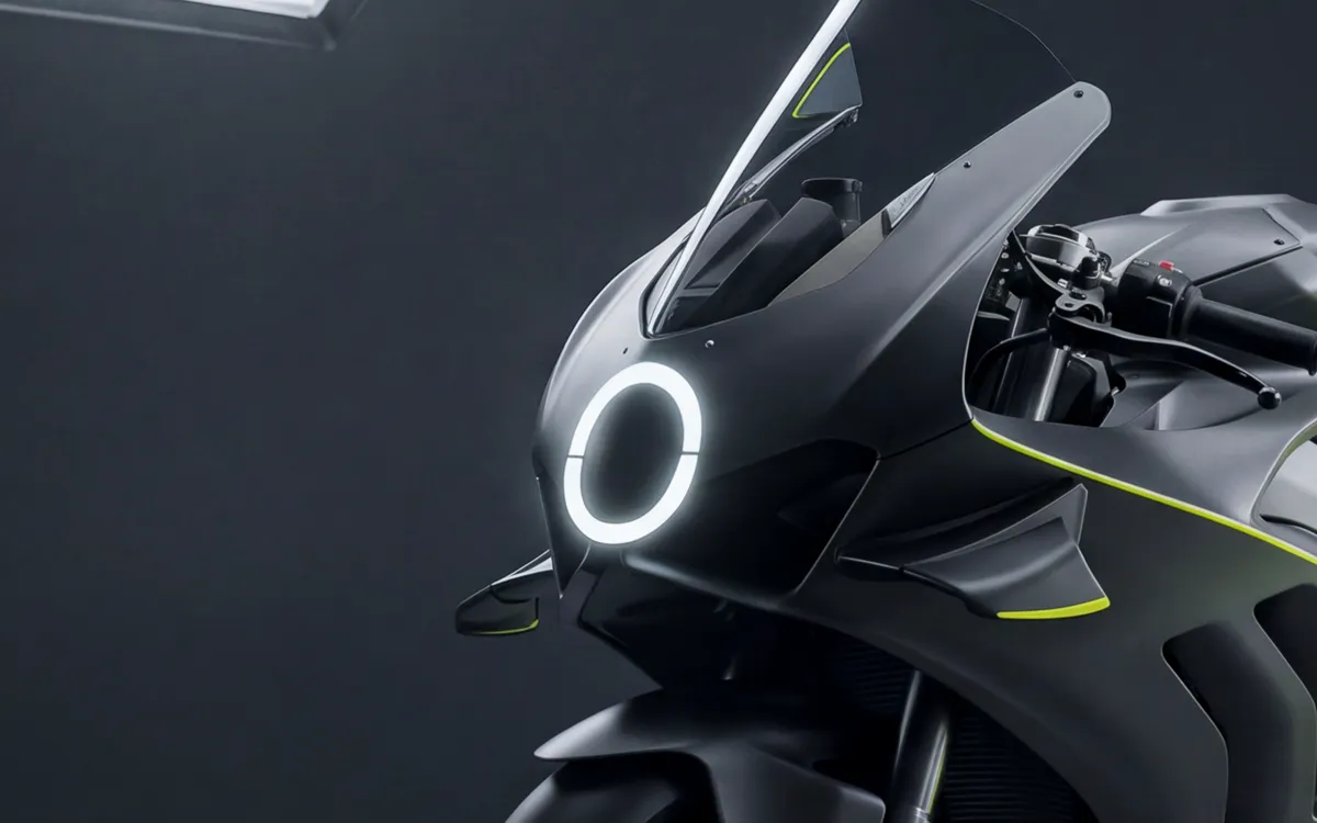 Close view of the unbroken ring headlamp glowing white on a dark fairing nose