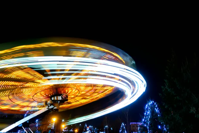 A ride at night reduced to a ring of light by a long exposure.